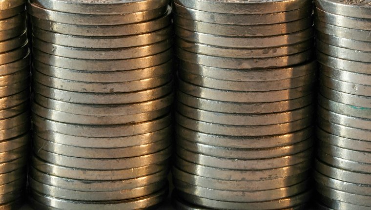 Close-up of tall stacks of silver coins standing in a row