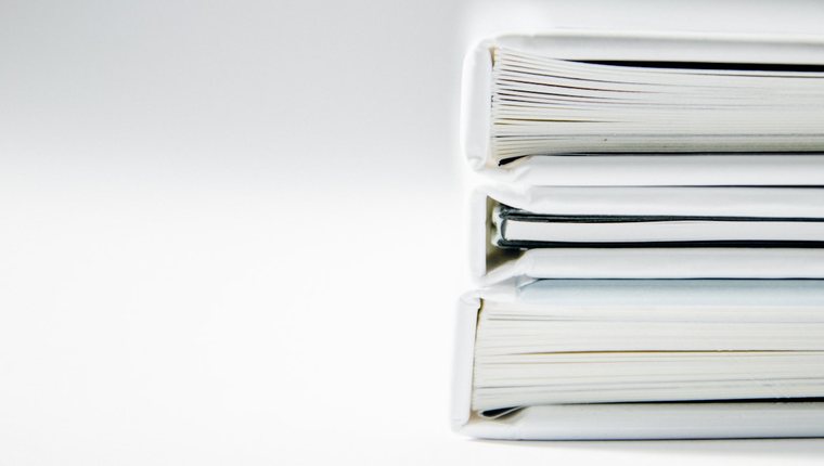 A stack of thick regulatory filing documents