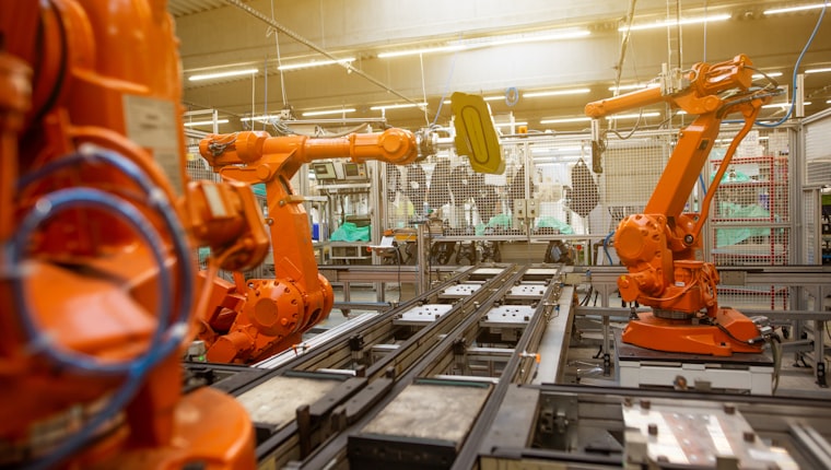 Robotic arms on an automated assembly line in a factory