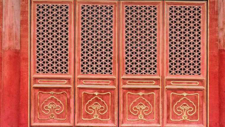 Closed red lattice doors of a traditional Chinese imperial hall