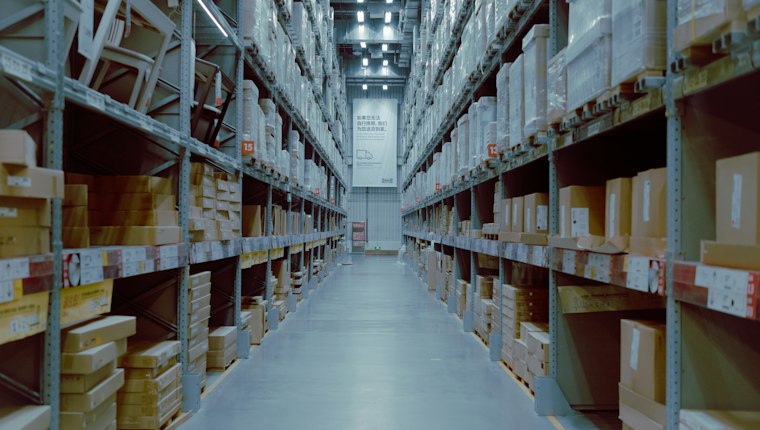 Warehouse aisle lined with shelves of cartons