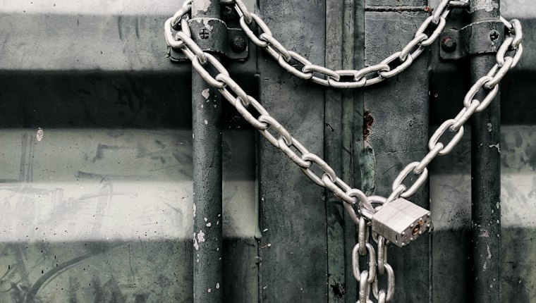 A metal door chained shut with a padlock